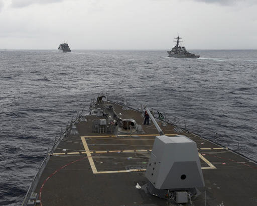 This Oct. 17, 2016 file image provided by the U.S. Navy, shows the guided missile destroyer USS Decatur, right, pulling into position behind the Military Sealift Command USNS Matthew Perry, during a replenishment-at-sea, seen from the bridge of the guided-missile destroyer USS Spruance, in the South China Sea. 