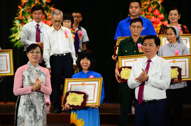 Bí thư Thành ủy TP.HCM Đinh La Thăng và Chủ tịch HĐND TP.HCM Nguyễn Thị Quyết Tâm trao tặng bằng khen cho các cá nhân và tập thể được tuyên dương - Ảnh: QUANG ĐỊNH