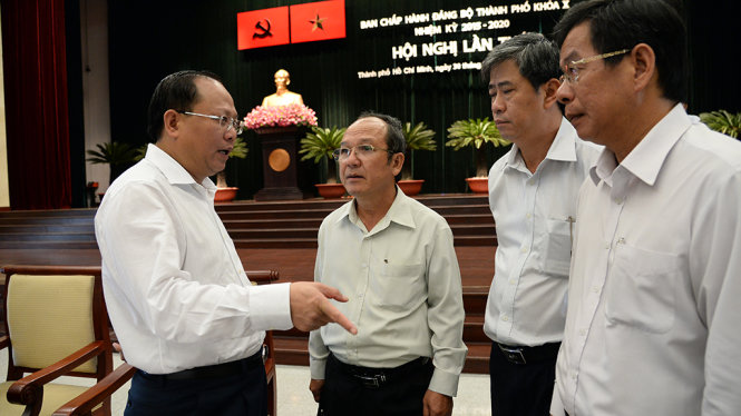 Phó bí thư thường trực Thành ủy Tất Thành Cang (bìa trái) trao đổi với các đại biểu tham dự hội nghị sáng 30-11 -        Ảnh: Tự Trung