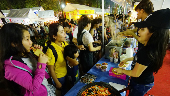 Người dân TP.HCM thưởng thức các món ăn của các nước trong lễ bế mạc lễ hội TP.HCM - Phát triển và hội nhập tối 3-12 tại công viên 30-4, Q.1, TP.HCM - Ảnh: QUANG ĐỊNH