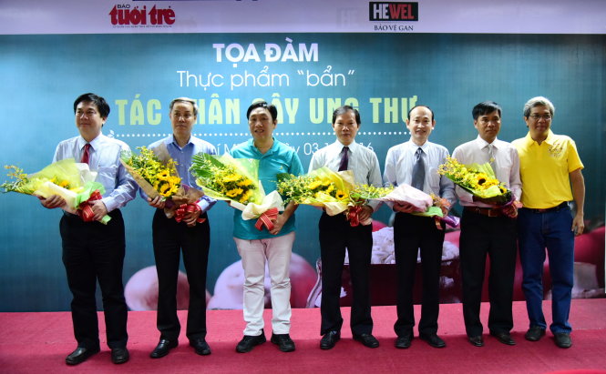 Ông Cao Huy Thọ - Phó tổng thư ký tòa soạn báo Tuổi Trẻ trao hoa cho những vị khách mời tại buổi tọa đàm Thực phẩm “bẩn” - Tác nhân gây ung thư - Ảnh: HỮU THUẬN