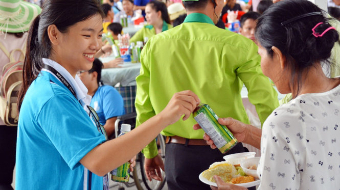 Các tình nguyện viên vui vẻ trao nước uống cho người tham gia ngày hội - Ảnh : Đại Việt