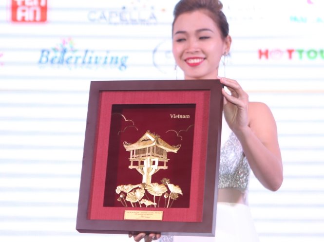 Món quà mà Lệ Hằng mang đến HHHV 2016 là bức tranh bằng vàng với hình ảnh chùa Một Cột - Ảnh: GIA TIẾN