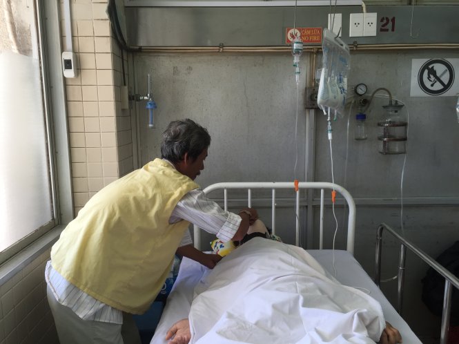 Ông Đặng Văn Long, 63 tuổi, đang chăm sóc con trai bị tai nạn khá nặng đang được điều trị tại Bệnh viện Chợ Rẫy - Ảnh: THÙY DƯƠNG