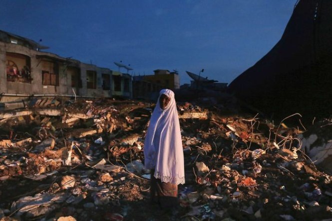 Một phụ nữ ở Meureudu, Aceh đứng giữa đống đổ nát do động đất gây ra - Ảnh: AP