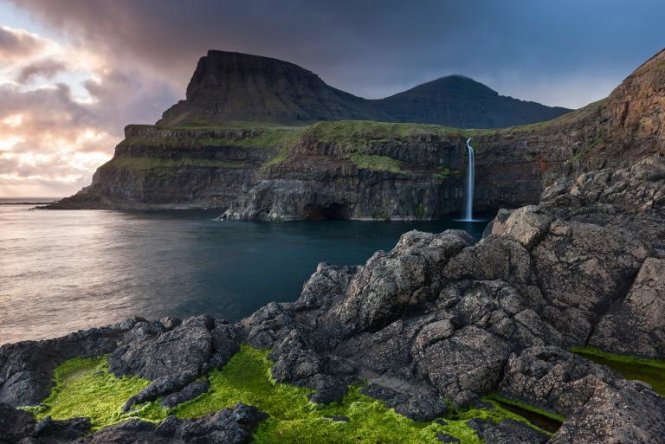 Làng Gásadalur trên quần đảo Faroe, Đan Mạch với dân số vỏn vẹn 18 người. Đây là ngôi làng trên thác nước mang tính biểu tượng của quần đảo. Năm 2004, một đường hầm được xây giúp dân làng dễ dàng qua lại với bên ngoài. Hiện du khách đã có thể đến đây bằng xe hơi - Ảnh: ADAM BURTON, JAI/CORBIS