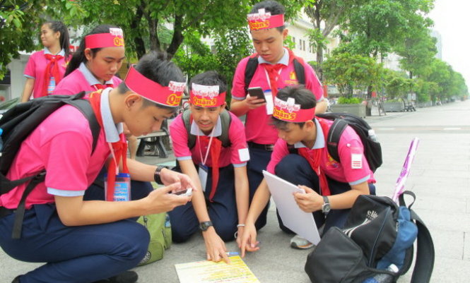 Các thành viên đội Hội đồng Đội Q.5 trả lời những thử thách bằng tiếng Anh trên phố đi bộ Nguyễn Huệ - Ảnh: K.ANH
