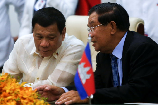 Tổng thống Duterte (trái) và Thủ tướng Hun Sen trao đổi trong lễ ký kết các thỏa thuận giữa hai nước vào chiều 14-12 ở Phnom Penh - Ảnh: Reuters