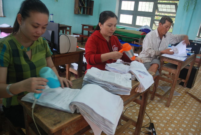 Giáo viên của Trường Tiểu học số 1 Cát Trinh (xã Cát Trinh, huyện Phù Cát, tỉnh Bình Định) hong khô sách vở, tài liệu sau khi sấy bằng máy sấy tóc. Ngôi trường này bị nước lũ tràn vào gây hư hỏng nhiều dàn máy tính, toàn bộ thiết bị điện tử và sách vở trong thư viện - Ảnh: Bá Dũng