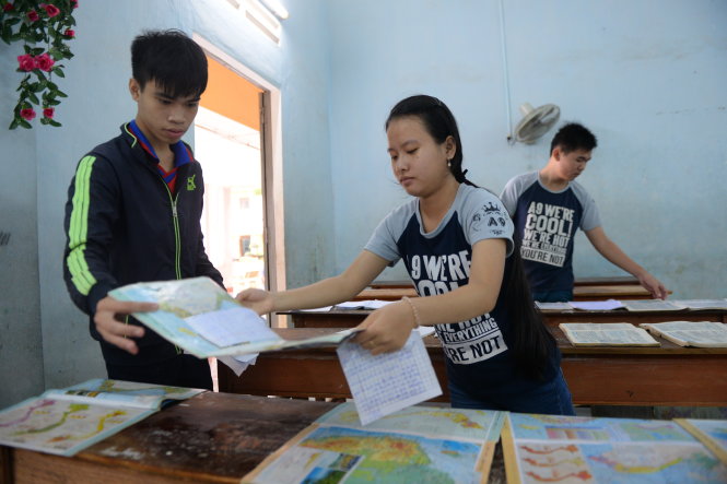Các em học sinh lớp 12 Trường THPT số 1 Tuy Phước, huyện Tuy Phước, tỉnh Bình Định) phơi lại sách vỡ bị ướt do nước lũ tràn vào trường - Ảnh: Hữu Khoa