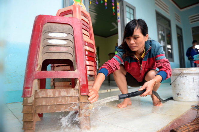 Cô Nguyễn Thị Thanh Thảo (giáo viên Trường mẫu giáo khu vực 6, TP.Quy Nhơn) cùng các bạn đoàn viên dọn bùn đất sau lũ - Ảnh: Hữu Khoa