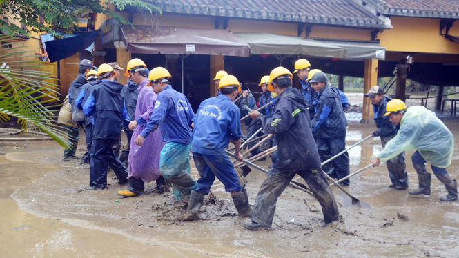 Từng tốp công nhân hì hục kéo bùn non - Ảnh: Thanh Ba