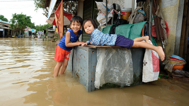 Trẻ em sống hai bên dòng sông Côn trog mùa lũ. Dự kiến nước sẽ rút hoàn toàn ở vùng rốn lũ Tuy Phước trong 3 ngày tới nếu trời không mưa - Ảnh: MAI VINH