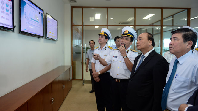 Thủ tướng Nguyễn Xuân Phúc lắng nghe lãnh đạo Tân cảng Sài Gòn giới thiệu về trung tâm điều hành của cảng - Ảnh: Thuận Thắng