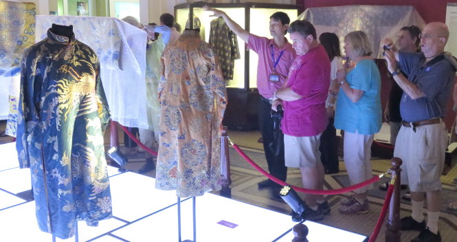 Du khách nước ngoài xem góc trưng bày các bộ nữ phục cung đình - Ảnh: L.Điền