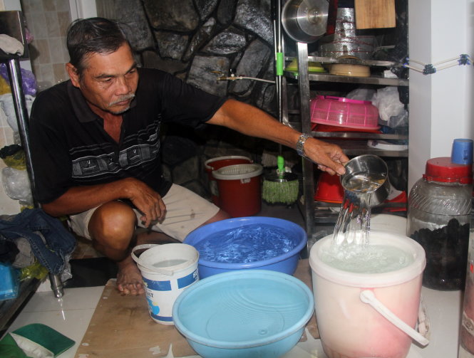 Sau hai ngày bị cúp nước vào đầu tháng 12, người dân ở đường Đào Tông Nguyên (Nhà Bè, TP.HCM) phải canh hứng nước ra thau, xô để dùng - Ảnh: Q.KHẢI