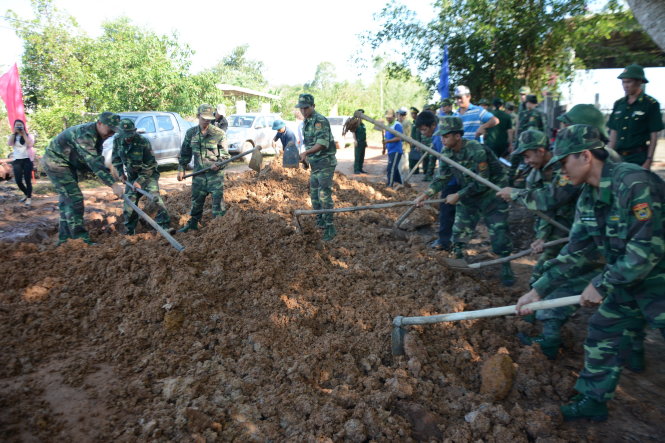 Cán bộ, chiến sĩ đồn biên phòng Vàm Trảng Trâu giúp dân sửa chữa đường sá hư hỏng tại xã Biên Giới, huyện Châu Thành - Ảnh: ĐỨC TRONG
