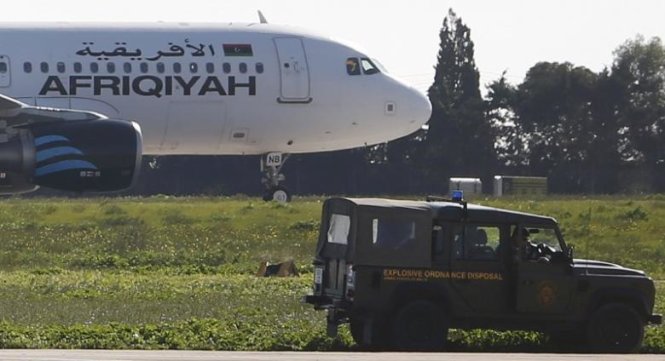 Xe của lực lượng an ninh gần chiếc máy bay bị không tặc - Ảnh: REUTERS
