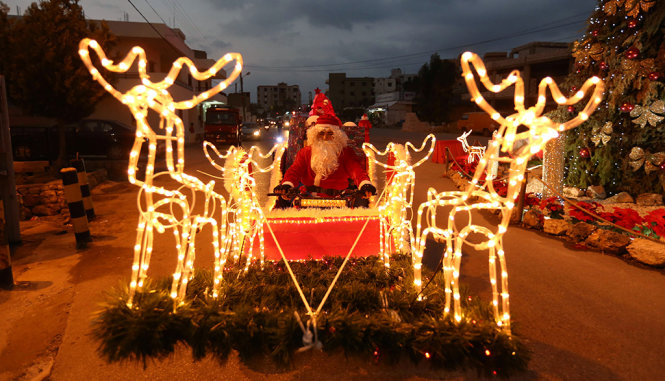 Ông già Noel với đàn tuần lộc bằng đèn chạy ngoài đường phố Thụy Điển - Ảnh: REUTERS