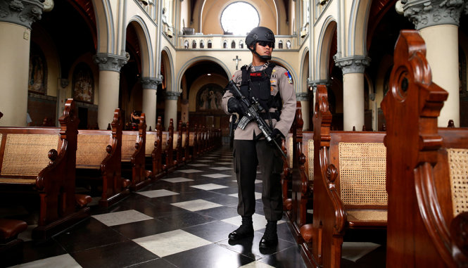 Cảnh sát kiểm soát an ninh cho một nhà thờ tại Indonesia trước đêm Giáng sinh - Ảnh: REUTERS