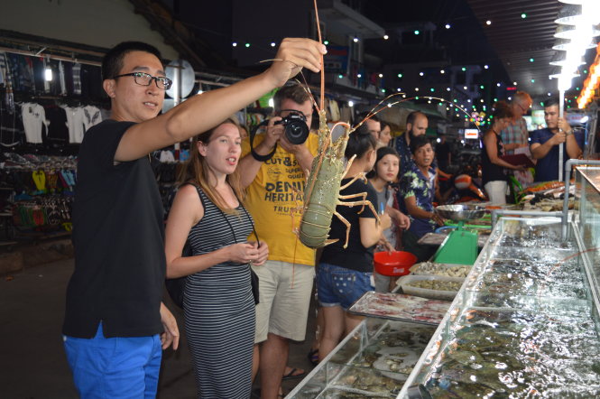 Du khách nước ngoài chọn hải sản tại chợ đêm Phú Quốc​ - Ảnh: Hoàng Trung