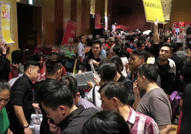 Khách chen nhau mua sắm tại một điểm bán hàng giảm giá nhân dịp Giáng sinh ở Q.1, TP.HCM tối 23-12 - Ảnh: T.T.D.