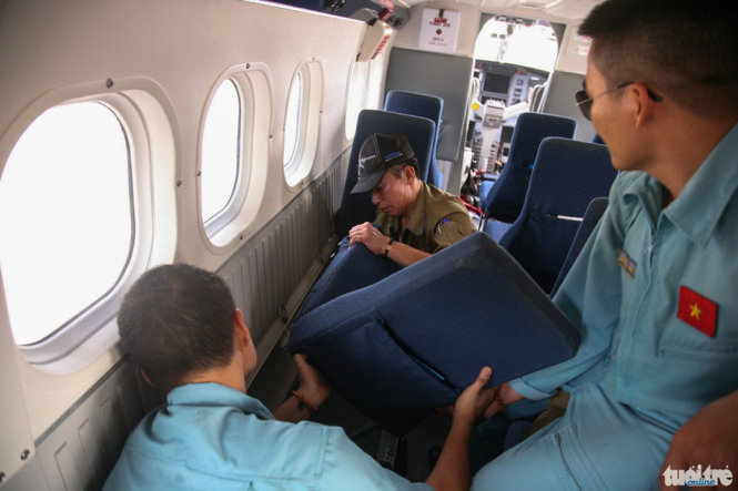 Các phi công và nhân viên kỹ thuật đang tháo bớt một số ghế trên máy bay để nhường chỗ để cáng thương cấp cứu bệnh nhân - Ảnh: VIỄN SỰ