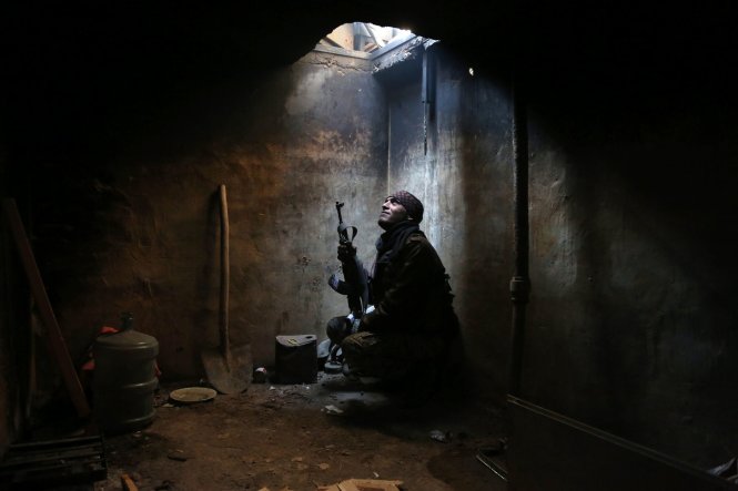 Một chiến binh chống chính phủ đang nấp trong một khu vực do lực lượng nổi dậy kiểm soát ở ngoại ô của thủ đô của Syria. Chiến tranh đã kéo dài tại quốc gia này trong gần 6 năm trời - Ảnh: AFP