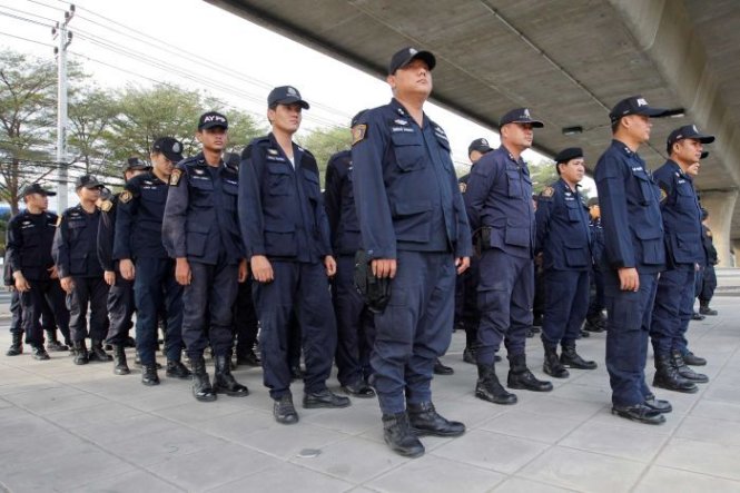 Cảnh sát đứng chờ lệnh bố ráp bên ngoài chùa Wat Phra Dhammakaya - Ảnh: Reuters