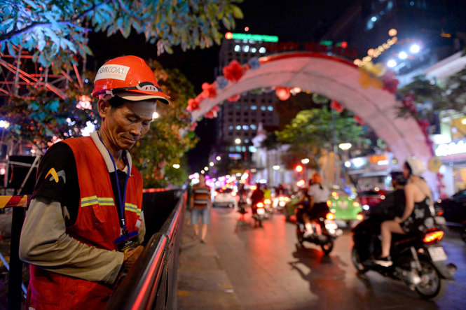 Công nhân hoàn tất hệ thống đèn khu vực phố đi bộ để người dân đón năm mới - Ảnh: HỮU KHOA