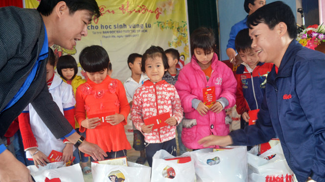 Đại diện báo Tuổi Trẻ (phải) và tỉnh đoàn Hà Tĩnh (trái) trao quà xuân đến học sinh nghèo Hà Tĩnh - Ảnh: VĂN ĐỊNH