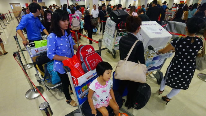 Xếp hàng chờ làm thủ tục tại sân bay Tân Sơn Nhất - Ảnh: QUANG ĐỊNH