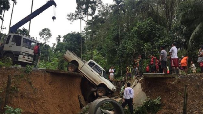 Một con đường ở tỉnh Nakhon Si Thammarat bị hư hỏng do mưa lũ - Ảnh: AFP