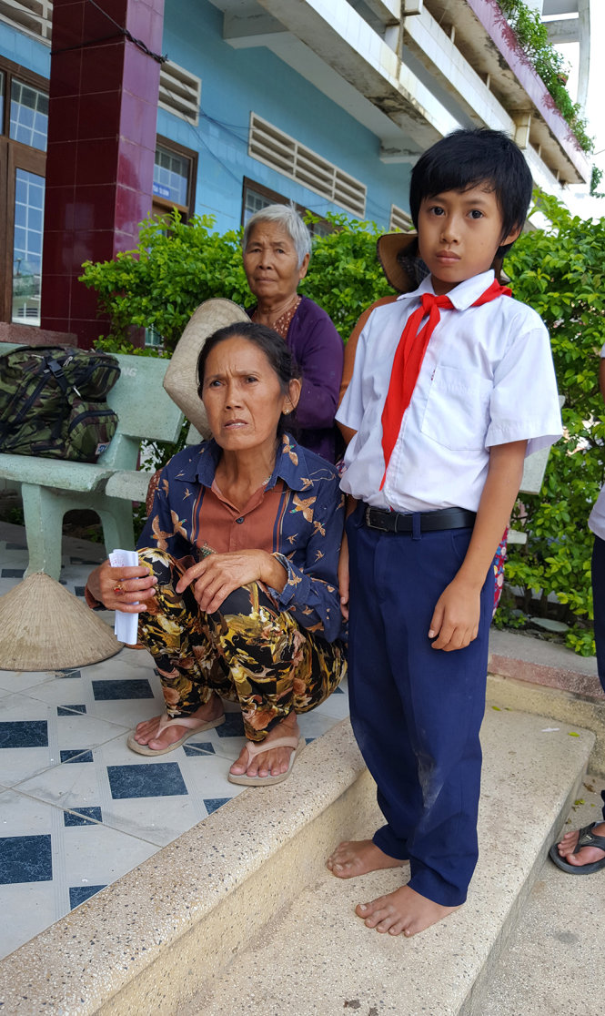 Em Nguyễn Minh Lâm, học sinh lớp 4B Trường tiểu học số 2 phường Nhơn Hòa, đến nhận quà với đôi chân trần vì lũ cuốn trôi dép, bà ngoại chưa kịp mua lại - Ảnh: DUY THANH