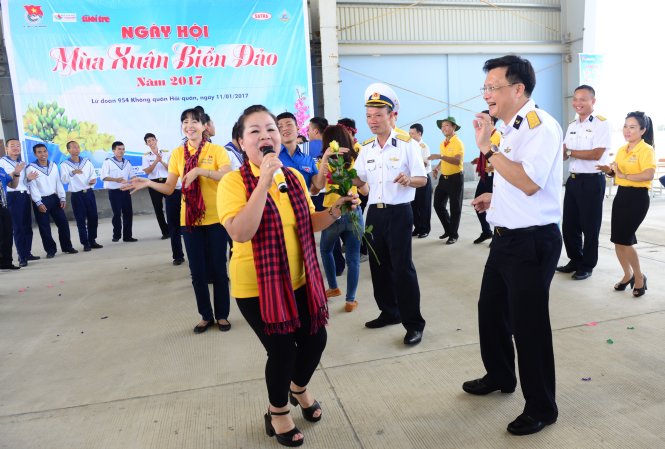 NSƯT Quỳnh Liên tay cầm hoa hồng hết mình biểu diễn cùng các chiến sĩ tại lữ đoàn 954 không quân hải quân - Ảnh: DUYÊN PHAN