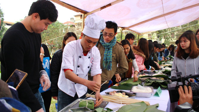 Các bạn du học sinh nước ngoài tại Việt Nam cùng sinh viên thủ đô tham gia gói bánh chưng ngày tết - Ảnh: HÀ THANH