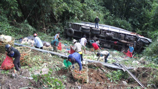 Người dân thu gom giúp tài xế số nông sản rơi vãi sau khi xe lật - Ảnh: Nguyễn Đông