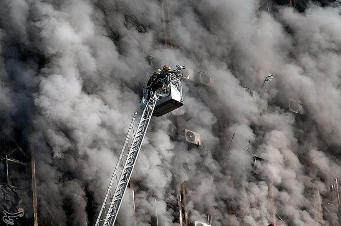 Khói bụi bao phủ tòa nhà khi lực lượng cứu hỏa đang cố gắng chữa cháy - Ảnh: Reuters