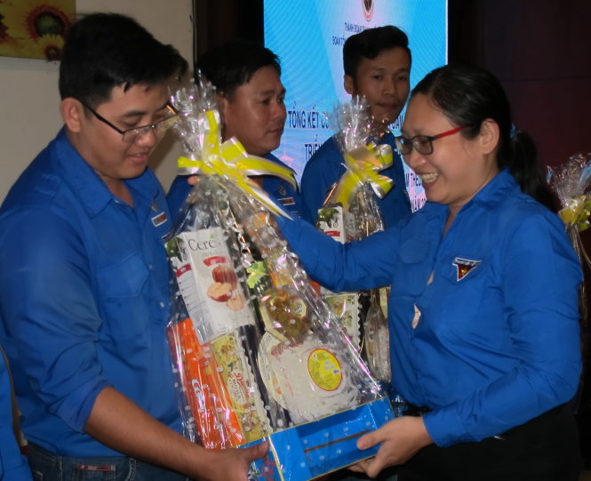 Chị Hồ Thị Đan Thanh, chánh văn phòng Thành đoàn TP.HCM, trao quà Tết đến thợ điện trẻ khó khăn - Ảnh: K.ANH