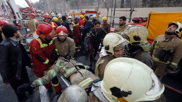 Nhân viên cứu hộ đưa người bị thương rời hiện trường - Ảnh: AFP