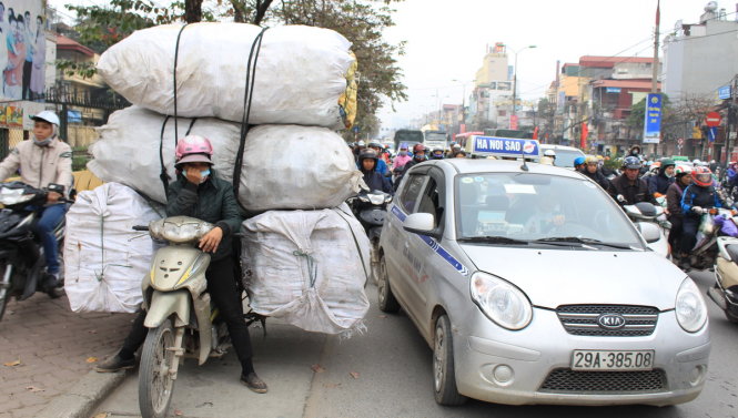 Một người phụ nữ chở hàng mệt mỏi với cảnh tắc đường tại thủ đô - Ảnh:  Chí Tuệ