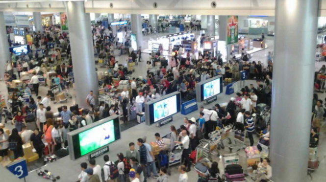 Trưa 20-1, hành khách tại ga đến sân bay quốc tế Tân Sơn Nhất rất đông - Ảnh: N.X.