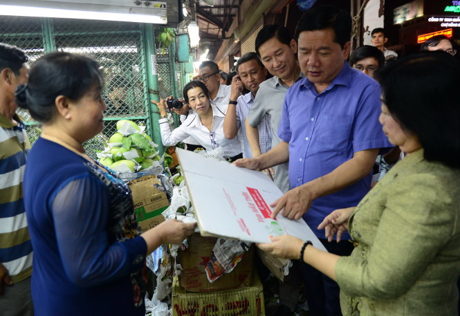 Bí thư Thành ủy TP.HCM Đinh La Thăng kiểm tra thùng đựng các loại
trái cây có thương hiệuđược bán tại chợ đầu mối Thủ Đức tối 24-01 - Ảnh:
QUANG ĐỊNH