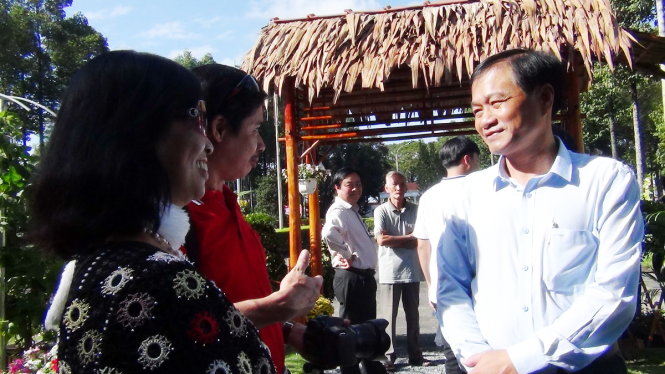 Ông Nguyễn Văn Dương, chủ tịch UBND tỉnh Đồng Tháp, trò chuyện với người dân tham quan - Ảnh: NGỌC TÀI