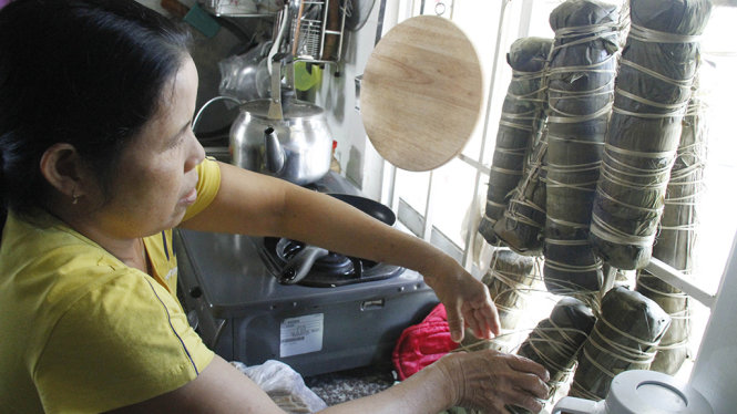 Cô Lương Thị Nguyện (58 tuổi, quê Quảng Nam) tự gói bánh Tét để đón Tết tại nhà ở xã hội – Ảnh: XUÂN AN