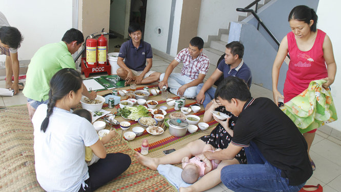 Nhiều gia đình công nhân không về quê ăn tết ngồi lại với nhau ăn tất niên ngày 30 tết - Ảnh: XUÂN AN