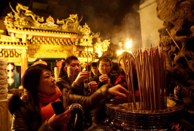 Người dân đi lễ chùa và thắp nhang cầu nguyện năm mới tại một ngôi đền ở thành phố Yokohama, Nhật Bản - Ảnh: Reuters