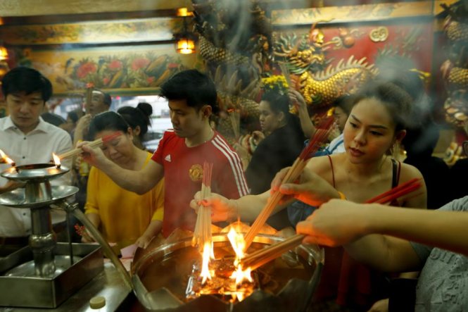 Tấp nập người dân thắp hương vào đêm giao thừa tại một ngôi chùa ở thủ đô Bangkok, Thái Lan - Ảnh: Reuters