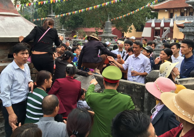 Nhiều du khách bất chấp việc ngăn cản của lực lượng chức năng vẫn trèo tường giành đường vào chùa trước khi cử hành lễ khai hội