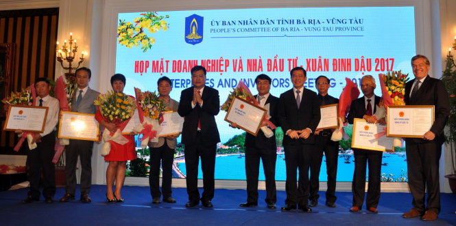 Lãnh đạo tỉnh Bà Rịa - Vũng Tàu trao giấy chứng nhận, chấp thuận chủ trương đầu tư và tặng hoa chúc mừng 8 nhà đầu tư - Ảnh: Đông Hà